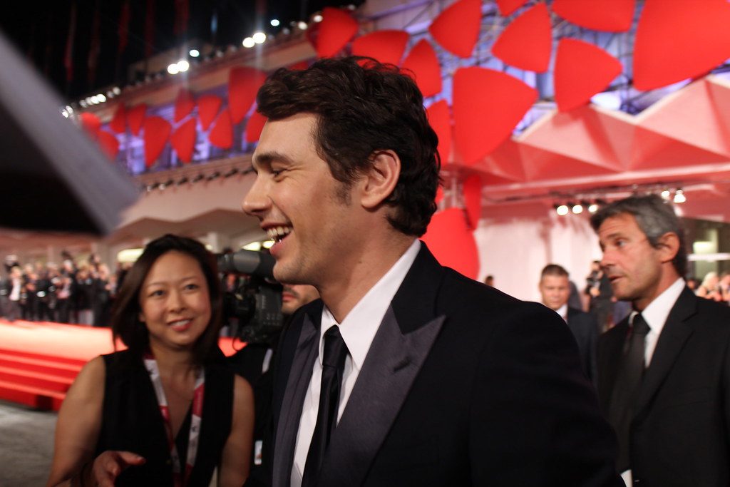 James Franco speaking with a reporter at the red carpet event.
