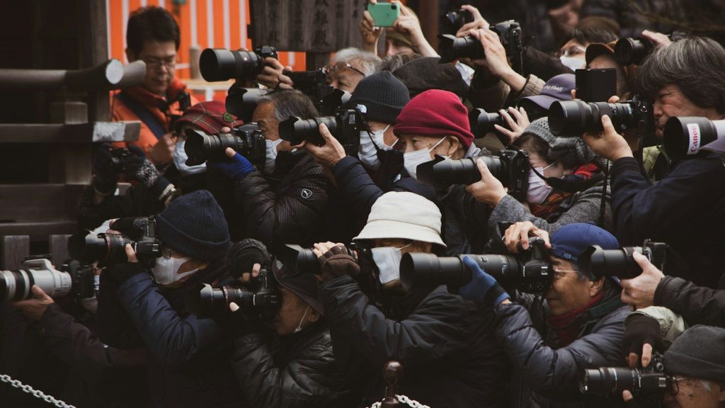 People in black jackets taking photos.