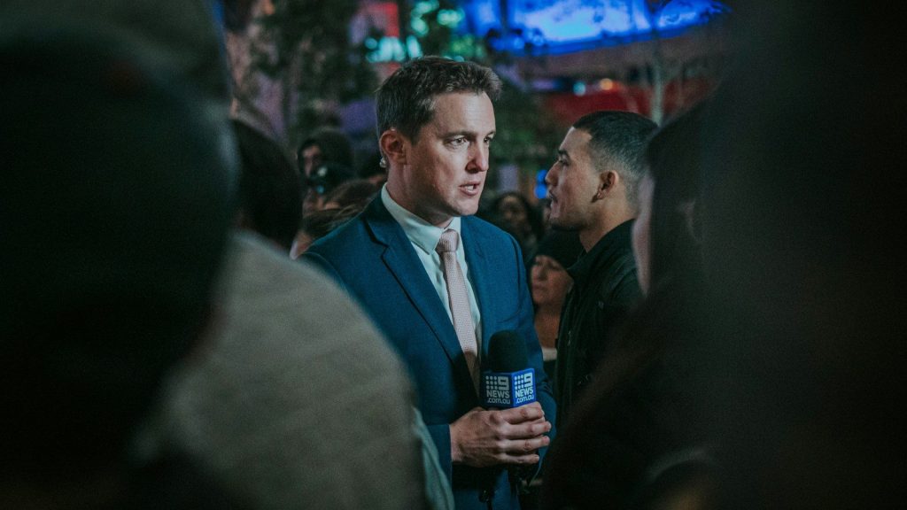 A man holding a microphone giving interview.