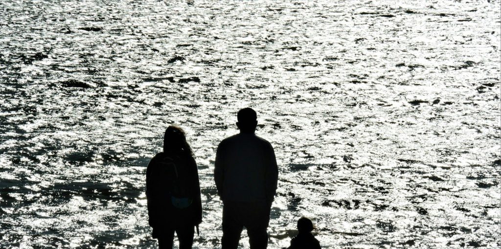 A couple standing on the seashore.