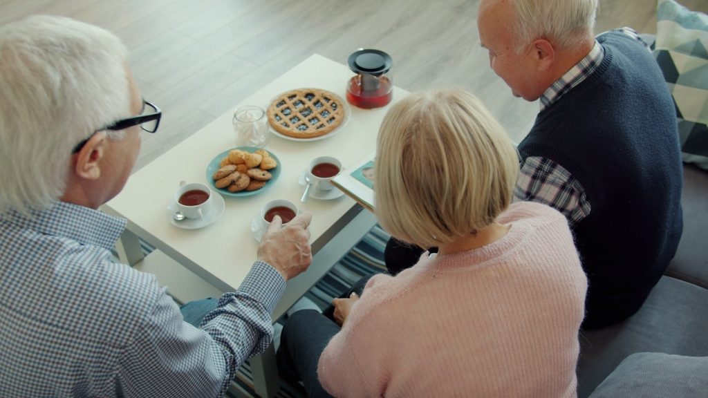 Three seniors enjoying tea and pie together.