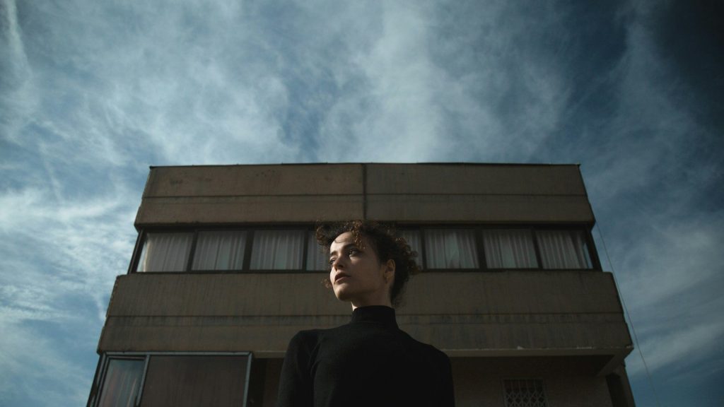 A woman standing in front of a building.