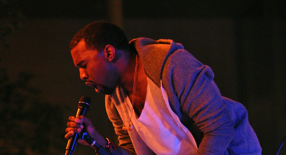 Kanye West performing at a live concert.
