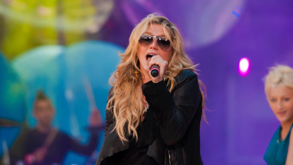 Kesha performing at a live concert.
