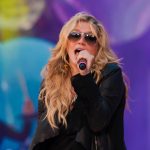 Kesha performing at a live concert.