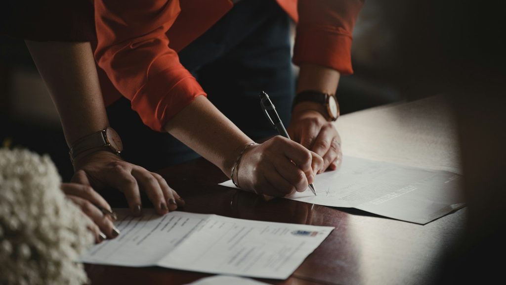 A man and a woman signing a paper.
