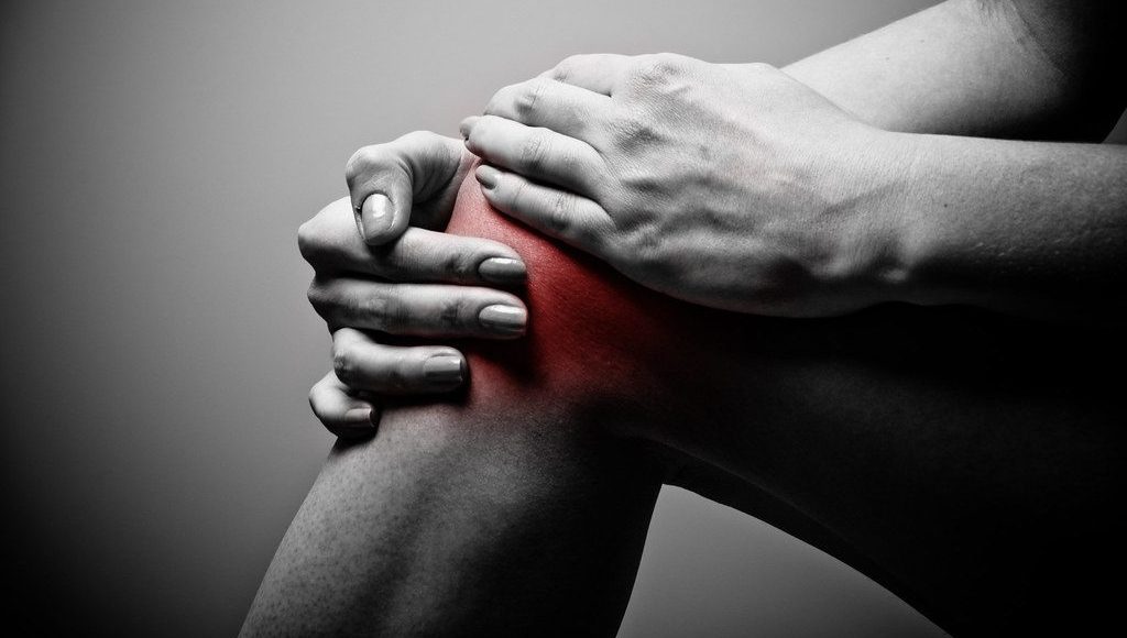 A person holding knee in pain.