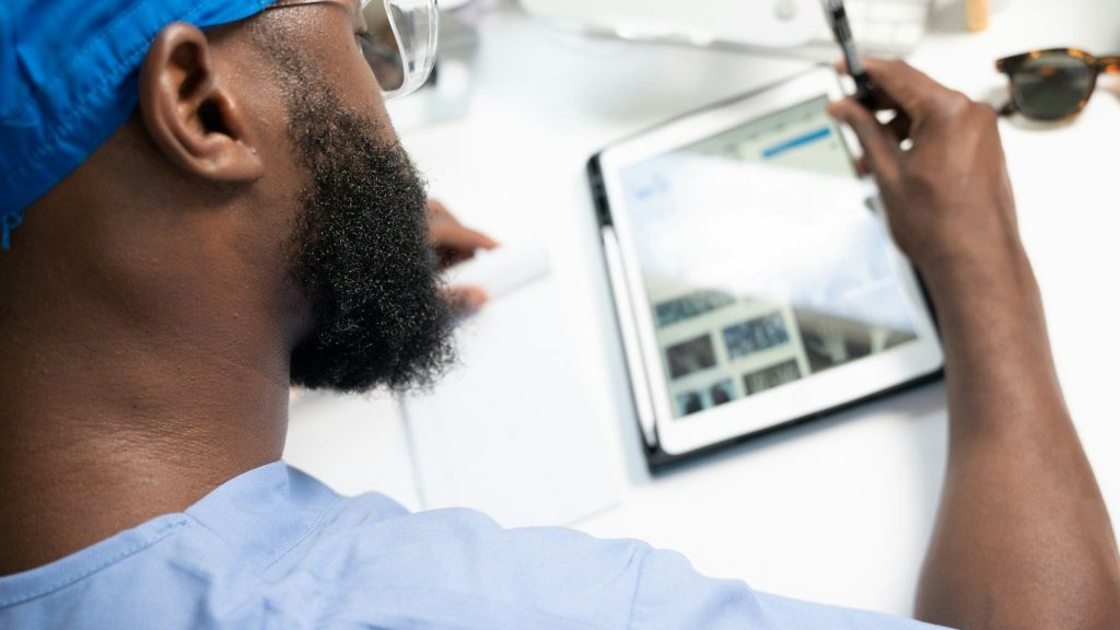 A doctor reviewing a patient's medical condition on a tablet.