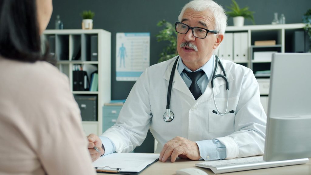 Doctor talking to patient in an office.