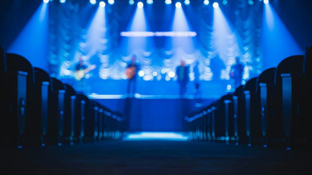 People standing on stage with blue lights.