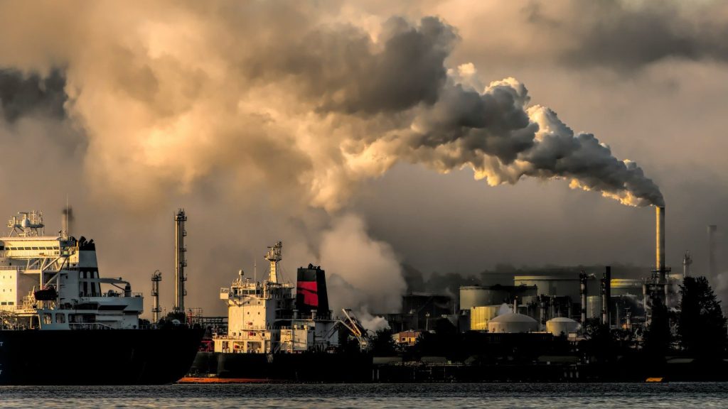 Industrial harbor with smokestack pollution.