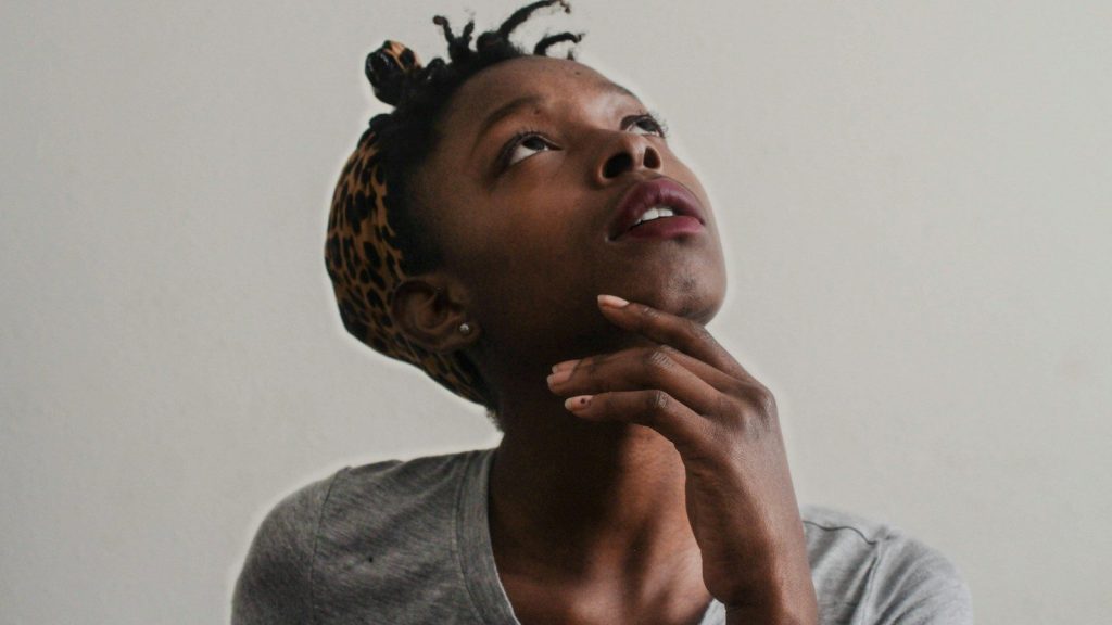 A woman in a gray top in deep thought.