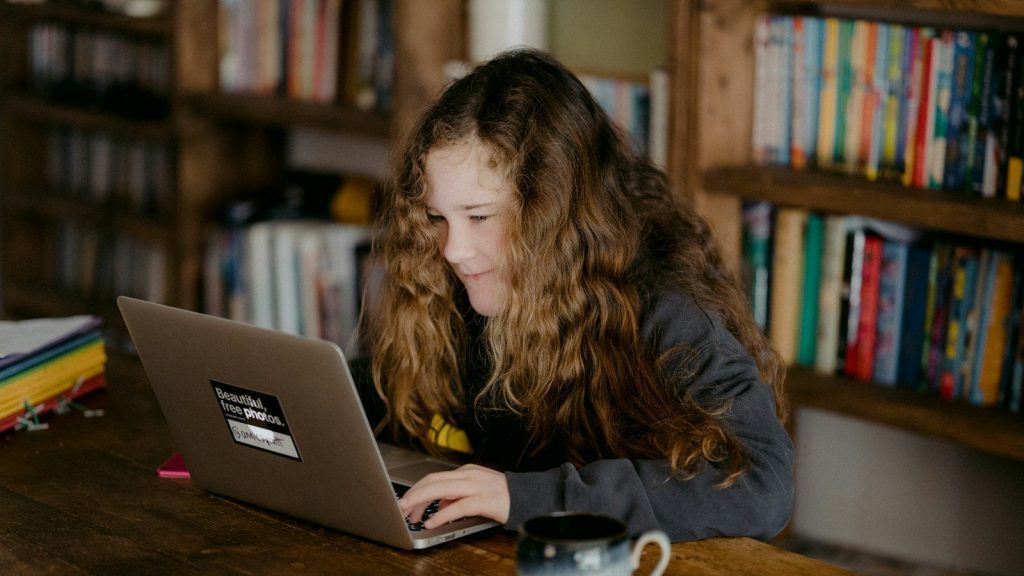 A girl working on a laptop.