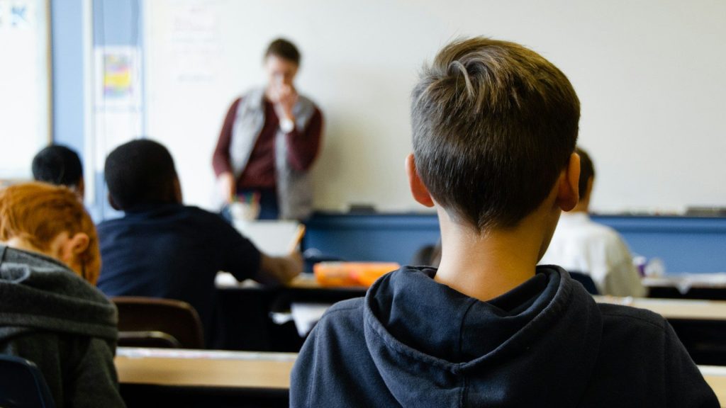 A boy sitting in a classroom.