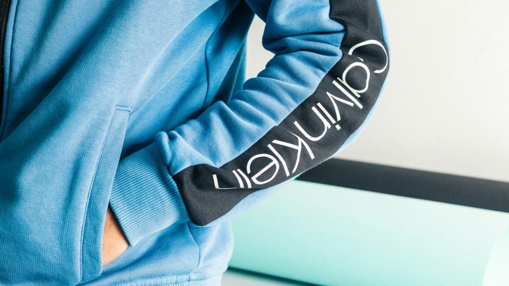 A person wearing a Calvin Klein blue sweatshirt.