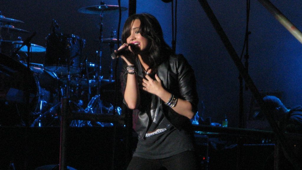 Demi Lovato performing at a live concert.