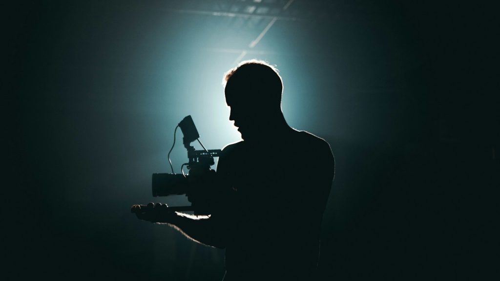 Silhouette of a man holding a camera.