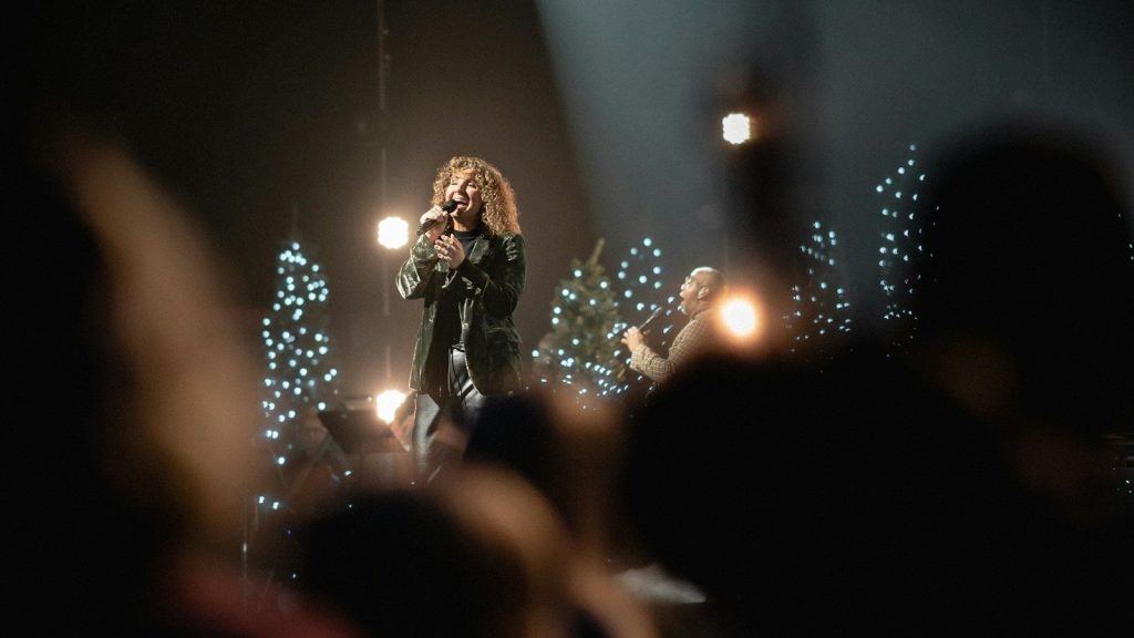 A woman standing on top of a stage holding a microphone.