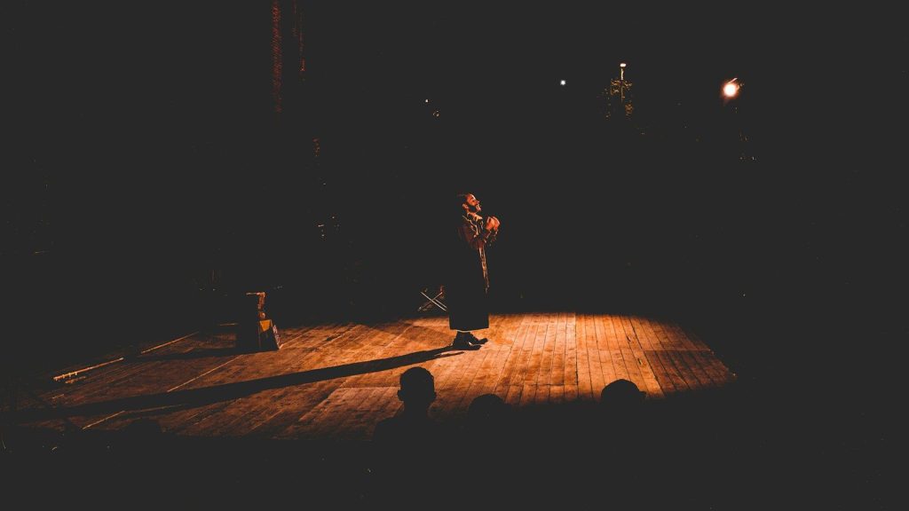A person standing on stage performing.