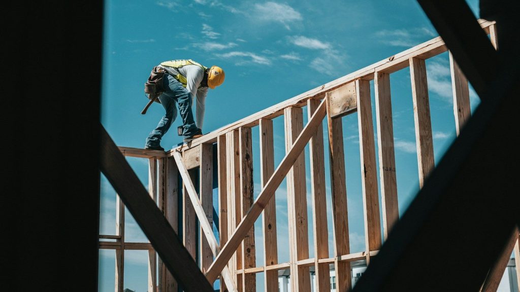 Construction worker in a hard hat on a building frame.