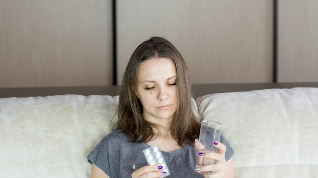 a woman sitting on a couch looking at her cell phone