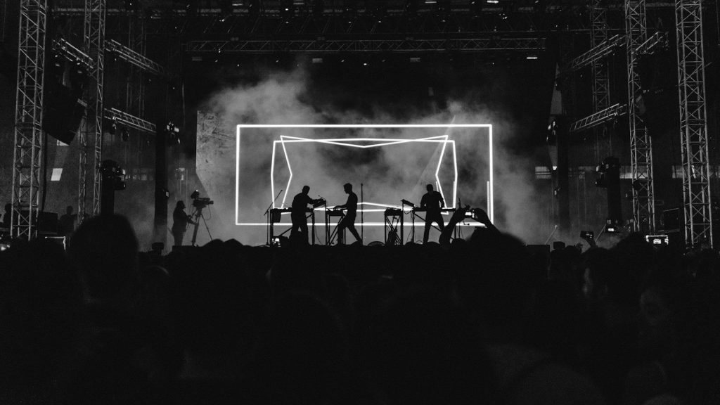 silhouette photo of rock band on stage performing in front of audience