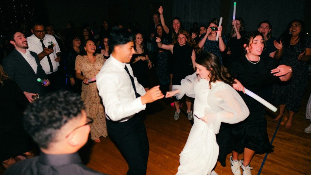 Guests dancing at a lively wedding reception.