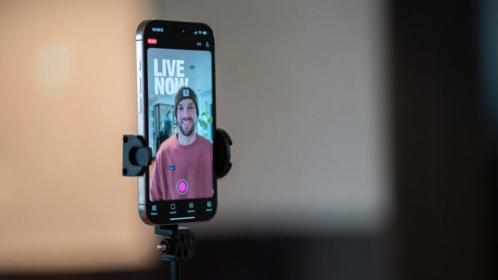 Person recording a video message on a smartphone for social media.
