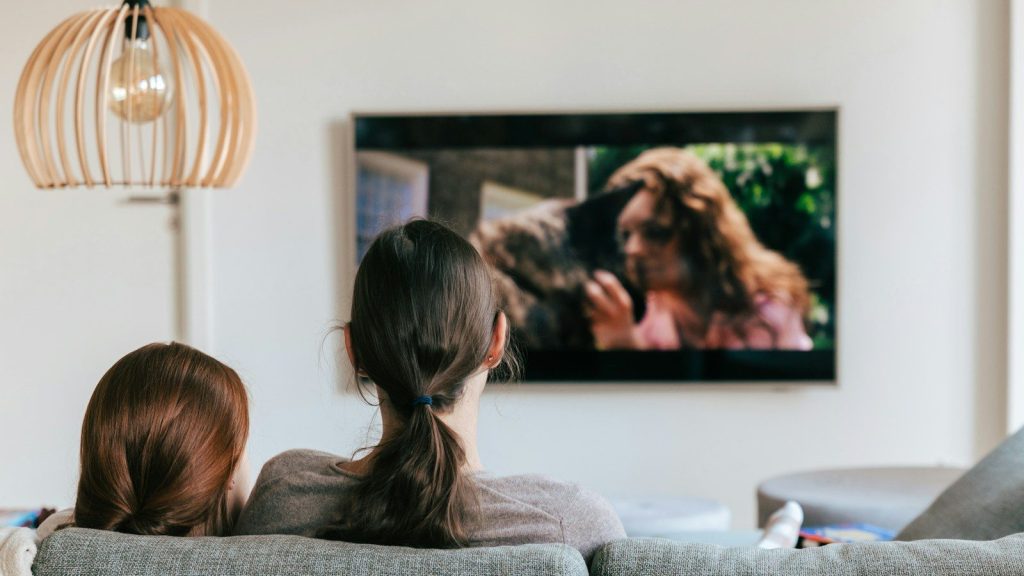 Two people watching a movie together on a television in their living room.
