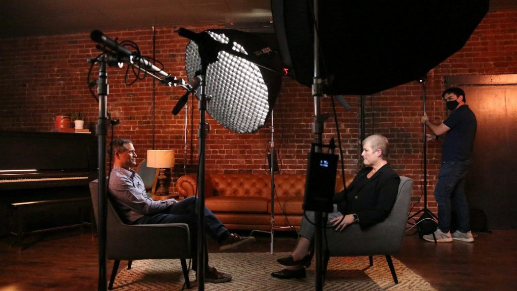 Professional interview recording with two people in conversation.