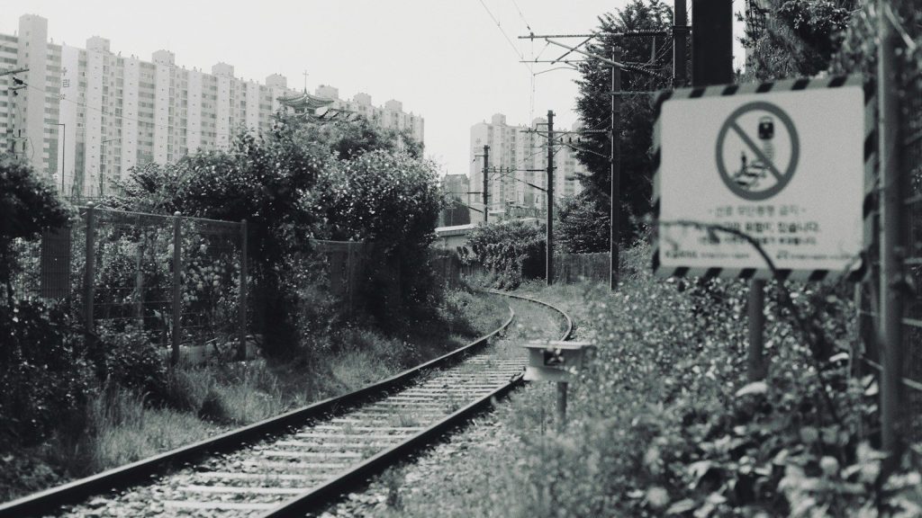 Railroad tracks with a no trespassing warning sign.