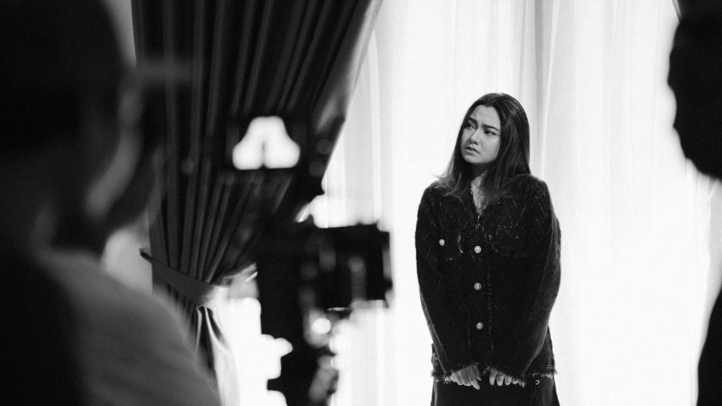 Young actress standing before a camera during an audition.