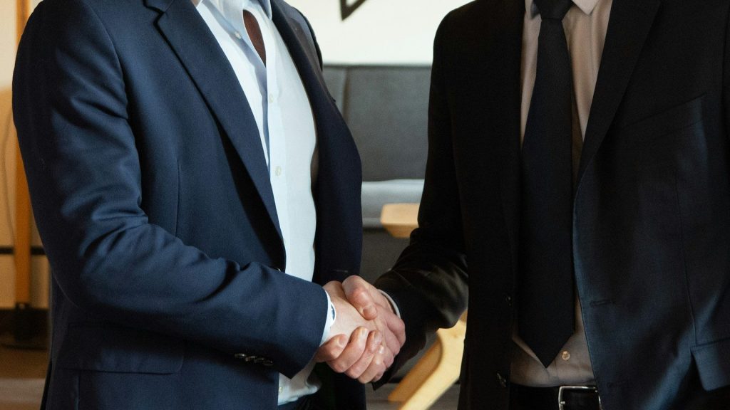 Two professionals shaking hands after a formal meeting.