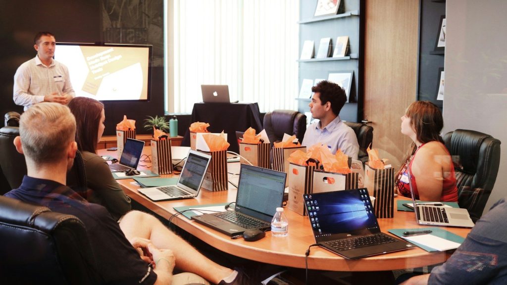 A man presenting to people in a conference room.