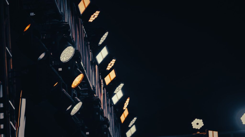 Stage lights illuminate a dark venue with warm glow