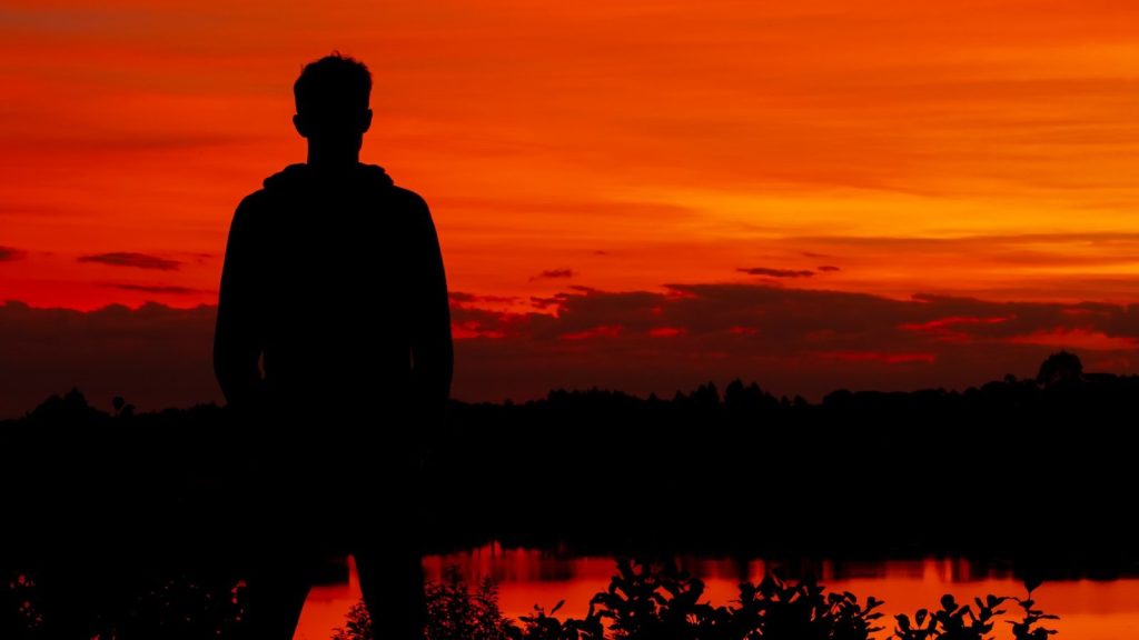 Silhouette at sunset in quiet reflection