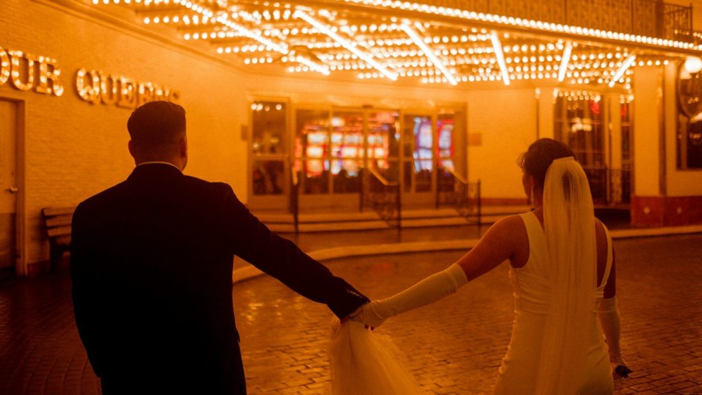 Bride and groom outside a Las Vegas wedding chapel at night.