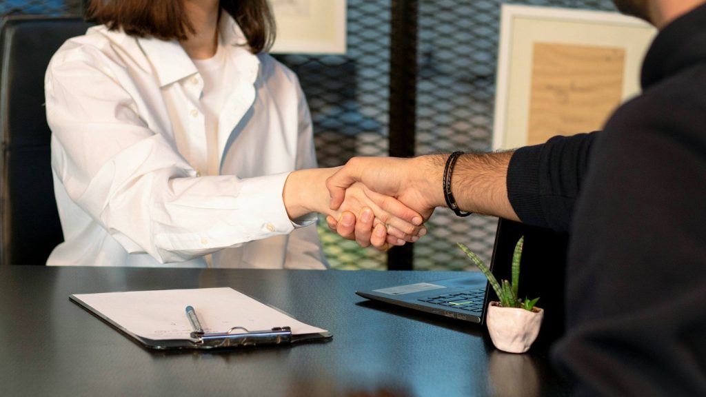 Two people shaking hands over an agreement.