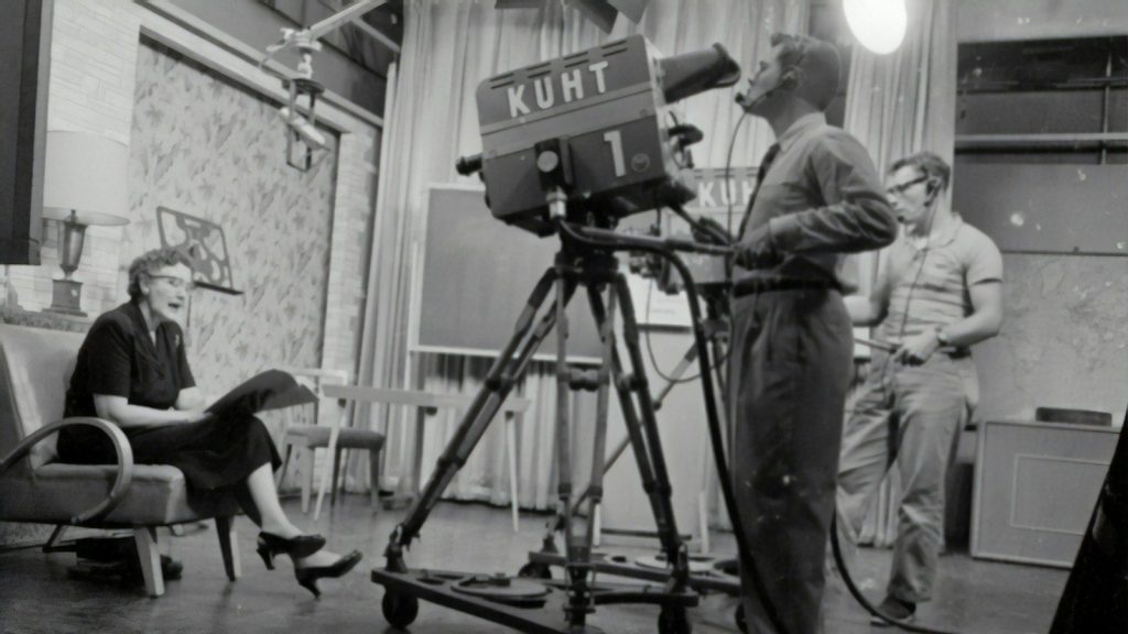 Vintage television studio with camera crew filming a scene.