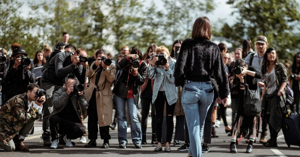 Photographers surround a woman taking pictures.